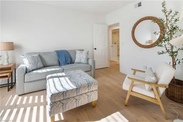 a living room with furniture a mirror and a lamp