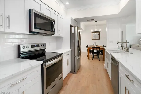 a kitchen with a sink and steel appliances