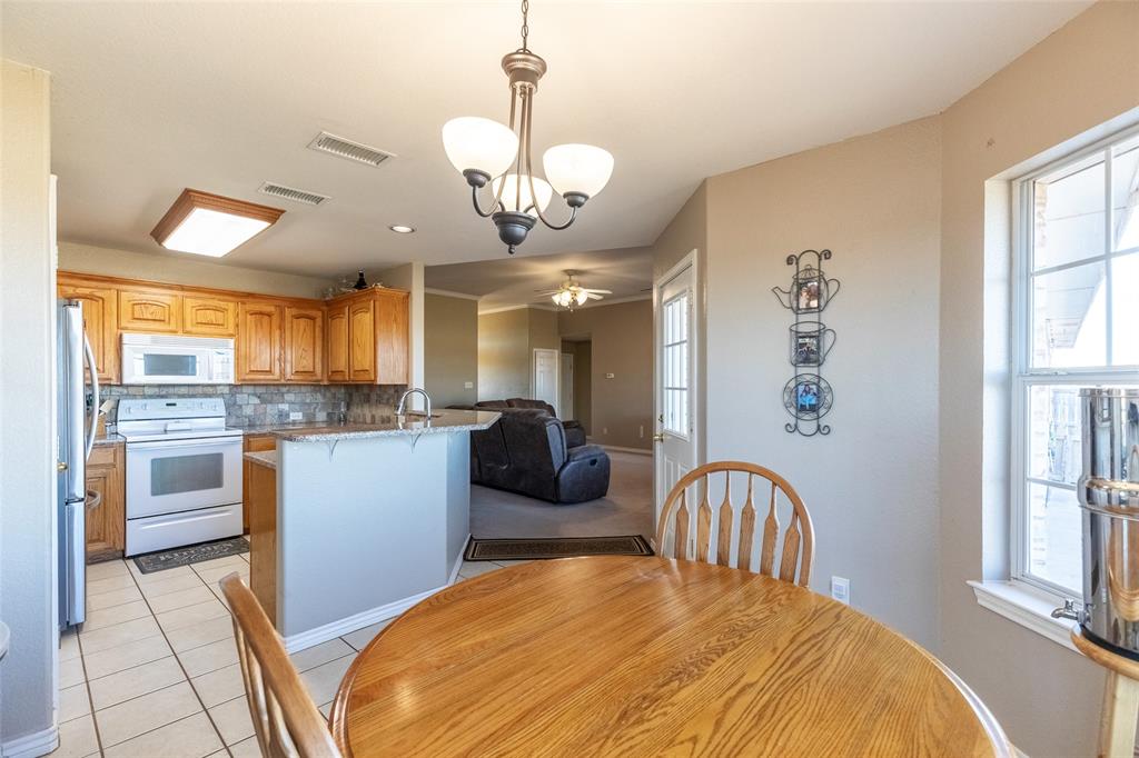2166 County Road 131 Tuscola, TX 79562 - Photo 13 of 40 a view of a dining room with furniture a chandelier and wooden floor