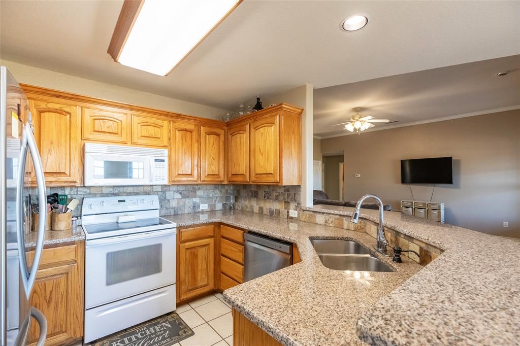 2166 County Road 131 Tuscola, TX 79562 - Photo 14 of 40 a kitchen with stainless steel appliances granite countertop a sink stove and refrigerator