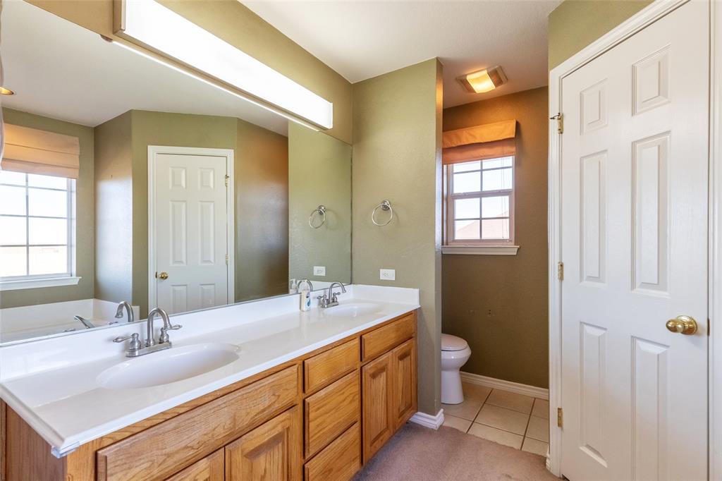 2166 County Road 131 Tuscola, TX 79562 - Photo 28 of 40 a bathroom with a double vanity sink toilet and a mirror
