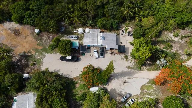 an aerial view of residential house with outdoor space and trees around