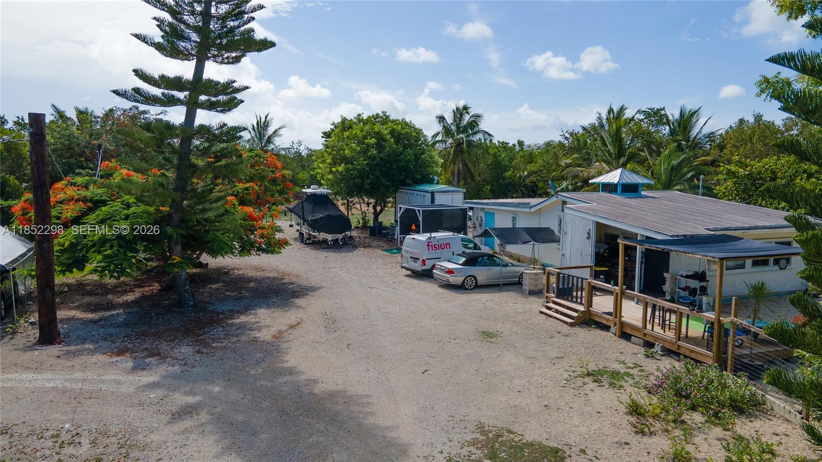 2231 Middle Torch Road Summerland Key, FL 33042 - Photo 21 of 36 a view of a patio with table and chairs potted plants and a palm tree