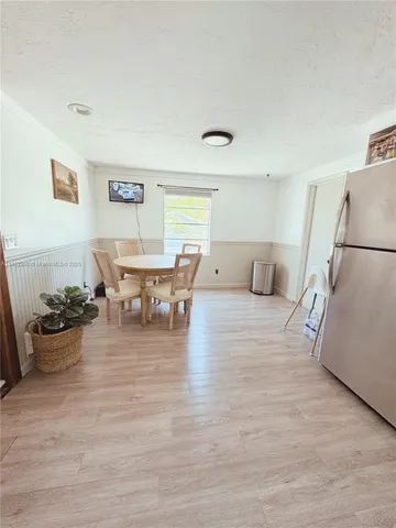 a living room with furniture and a dining table with wooden floor