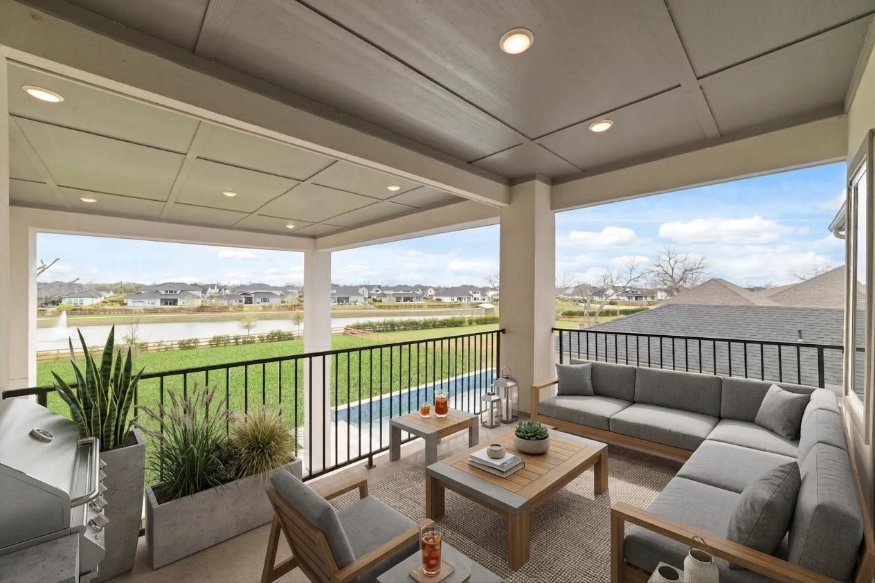 29627 Cir S Rnch Trail Fulshear, TX 77406 - Photo 35 of 50 Covered balcony living with panoramic lake views, seamlessly connected to the game room for effortless indoor-outdoor entertaining.