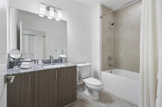 a bathroom with a granite countertop sink a toilet and shower