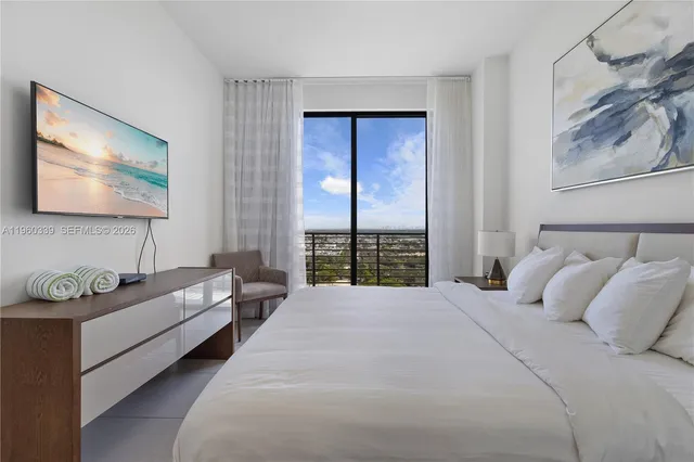 a spacious bedroom with a bed a couch and large window