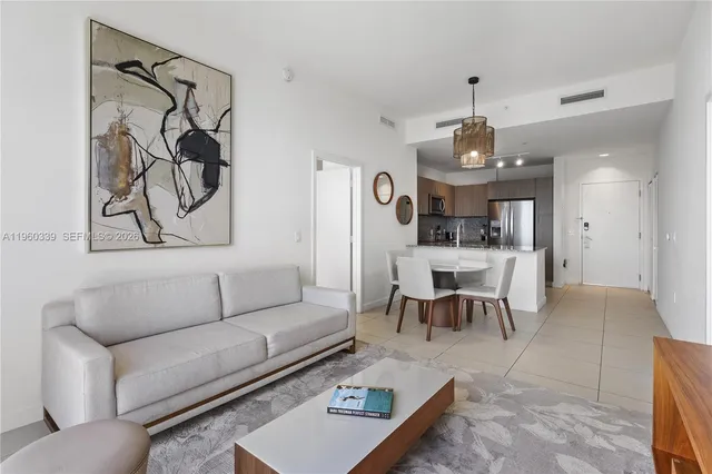 a living room with furniture kitchen view and a chandelier