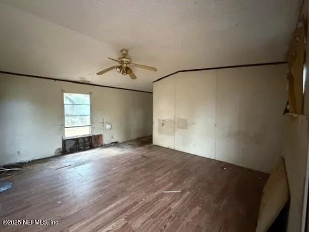 a living room with stainless steel appliances furniture a kitchen view and wooden floor