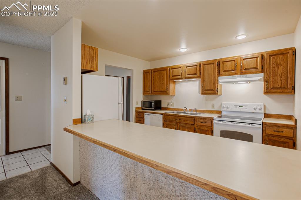 1140 Magic Lamp Way, Unit 3 Monument, CO 80132 - Photo 12 of 26 a kitchen with stainless steel appliances a refrigerator and a stove top oven