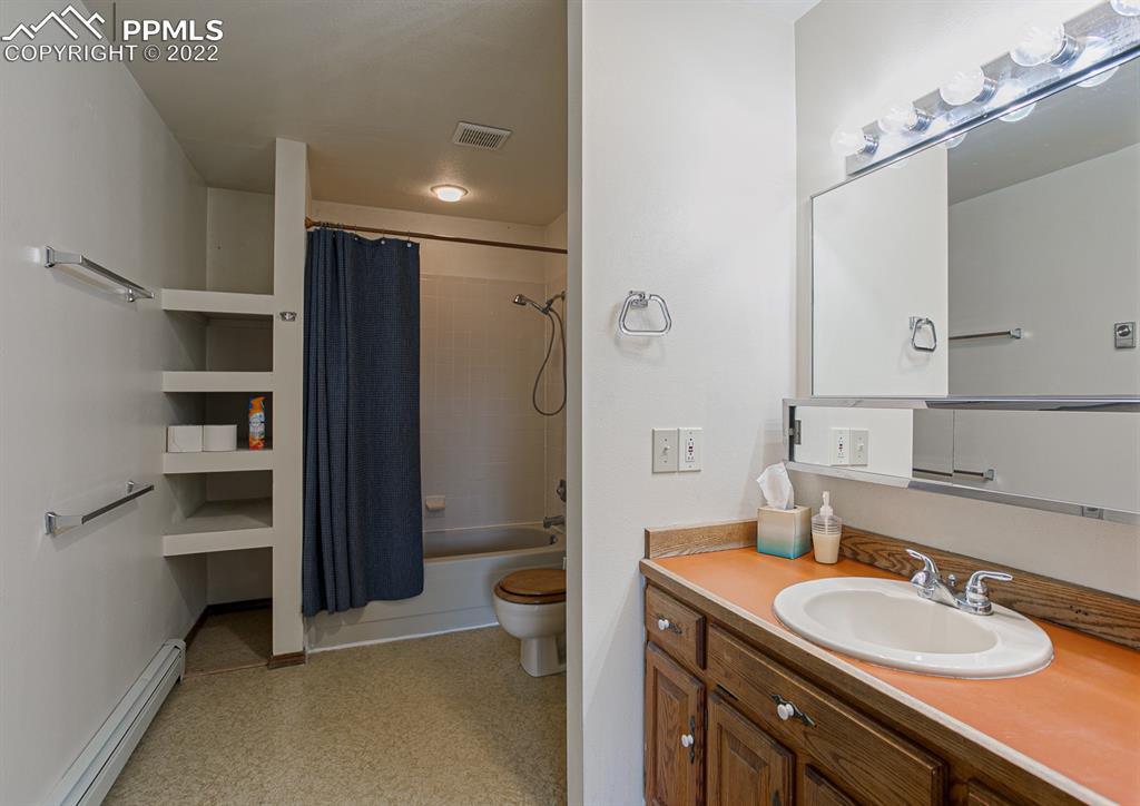 1140 Magic Lamp Way, Unit 3 Monument, CO 80132 - Photo 23 of 26 a bathroom with a granite countertop sink a toilet and a mirror
