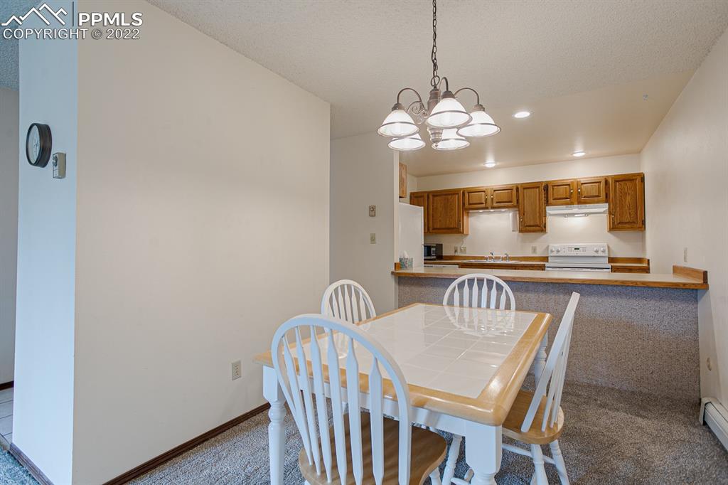 1140 Magic Lamp Way, Unit 3 Monument, CO 80132 - Photo 10 of 26 a view of a dining room with furniture and a chandelier