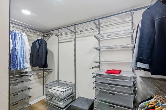 a view of walk in closet with clothes and shoes