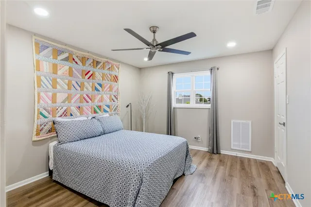 a bedroom with a large bed and a chandelier
