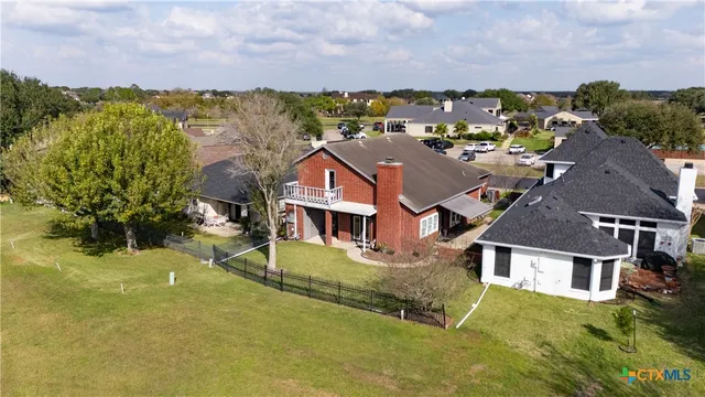 an aerial view of residential houses with outdoor space and ocean view