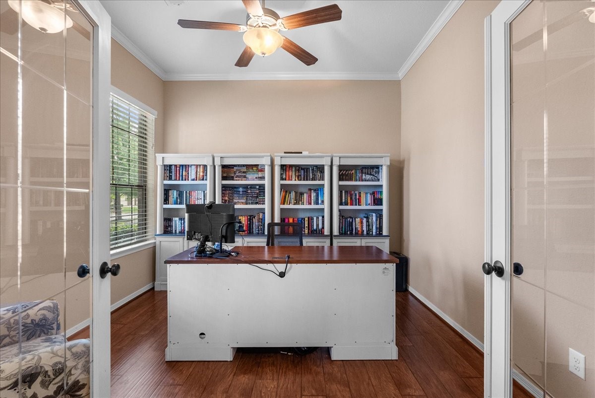 606 West Fork Webster, TX 77598 - Photo 3 of 46 Private home office featuring elegant French doors and custom built-in bookshelves, offering the ideal quiet workspace in this Edgewater, Webster home.