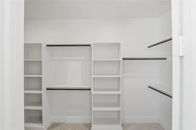 a view of walk in closet with empty racks