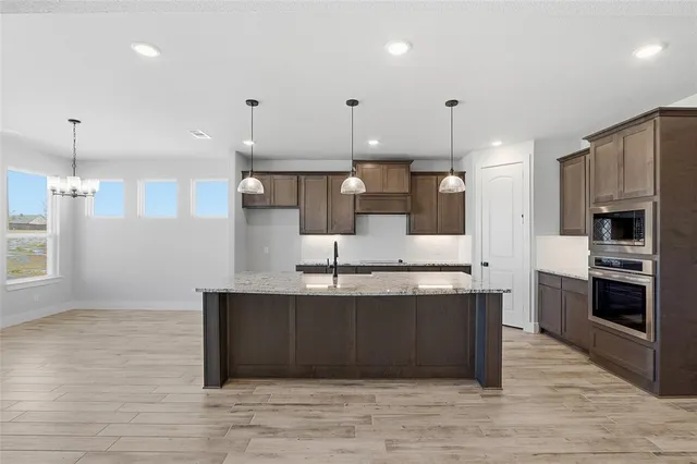 a kitchen with kitchen island a sink stainless steel appliances and cabinets