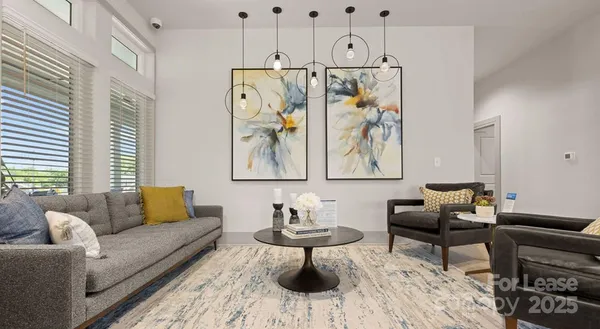 a living room with furniture a flat screen tv and a chandelier