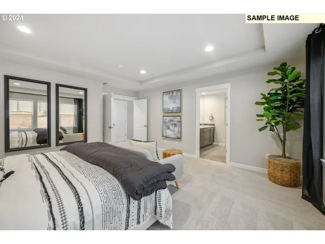 a spacious bedroom with a large bed and a potted plant