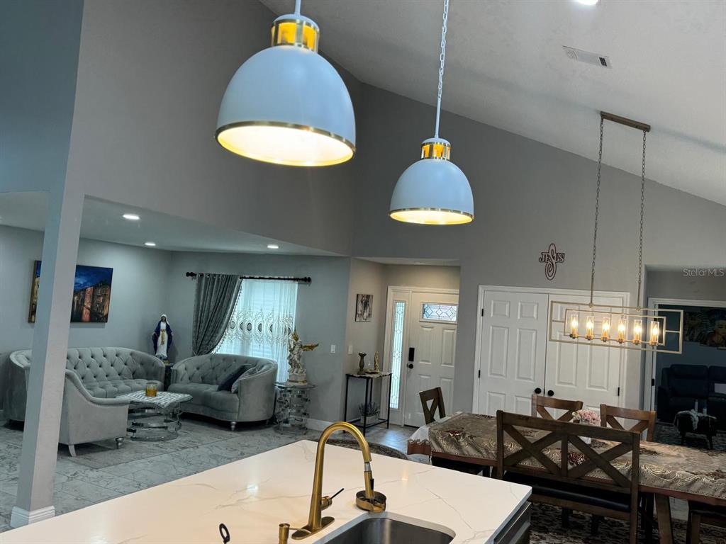 5221 Spike Horn Drive New Port Richey, FL 34653 - Photo 11 of 34 a living room with furniture a dining table and a chandelier