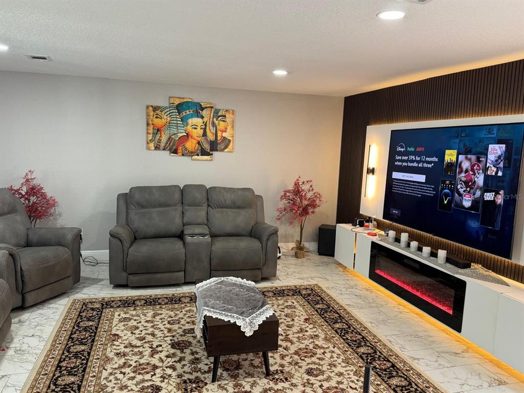 5221 Spike Horn Drive New Port Richey, FL 34653 - Photo 14 of 34 a living room with furniture a rug and a flat screen tv