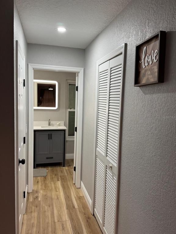 5221 Spike Horn Drive New Port Richey, FL 34653 - Photo 18 of 34 a view of a hallway with bathroom and wooden floor