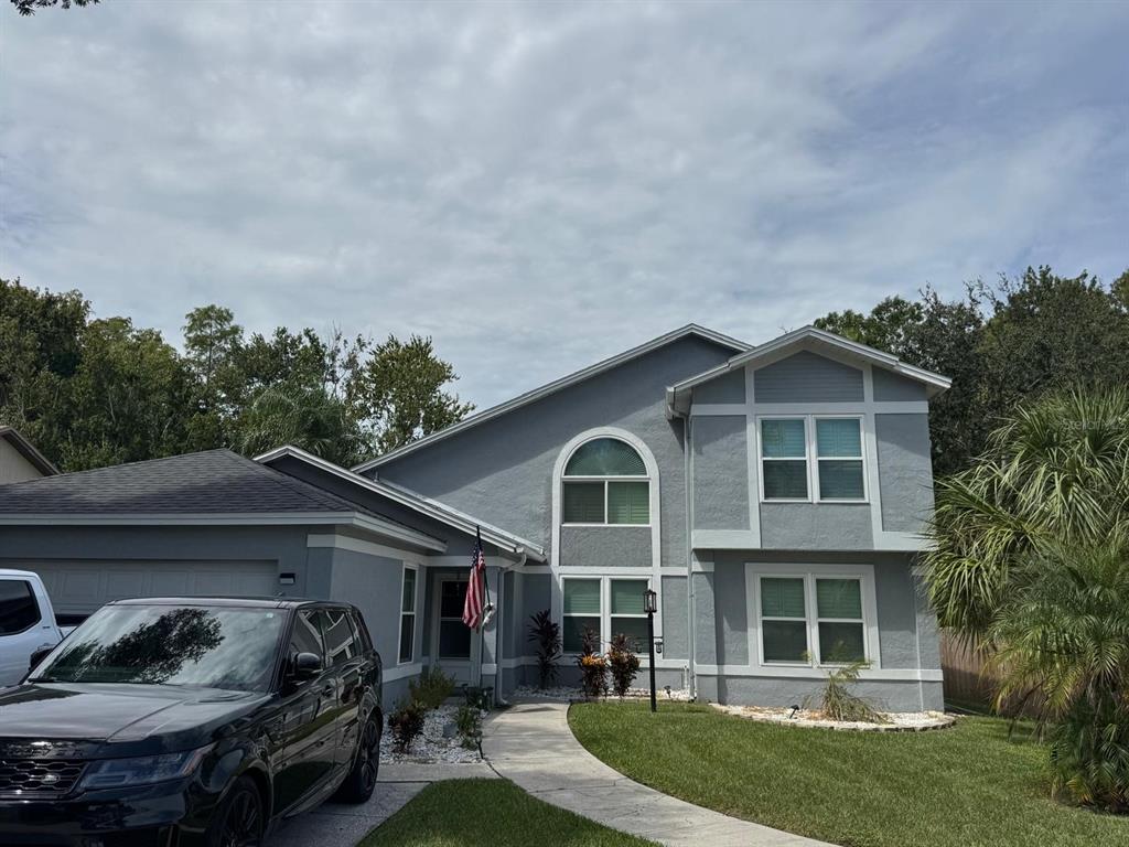 5221 Spike Horn Drive New Port Richey, FL 34653 - Photo 2 of 34 a front view of a house with a garden