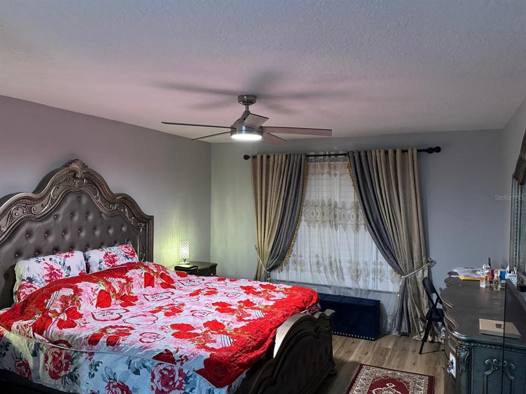5221 Spike Horn Drive New Port Richey, FL 34653 - Photo 23 of 34 a bedroom with a bed and a chandelier