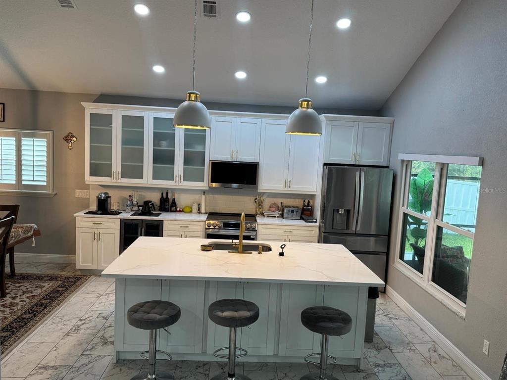5221 Spike Horn Drive New Port Richey, FL 34653 - Photo 8 of 34 a kitchen with a stove a refrigerator a sink dishwasher with a dining table and chairs
