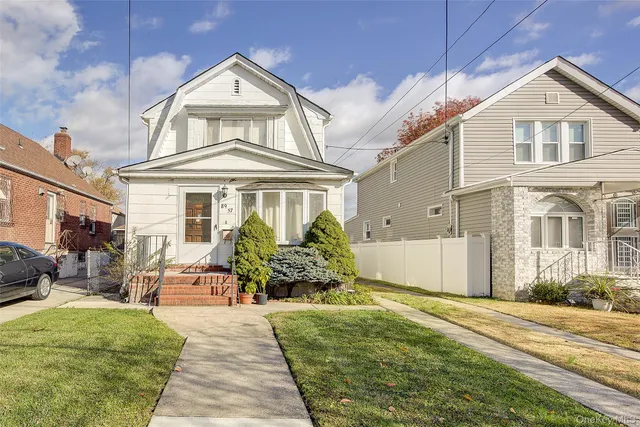 a front view of a house with a garden
