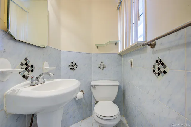 a bathroom with a toilet sink and mirror