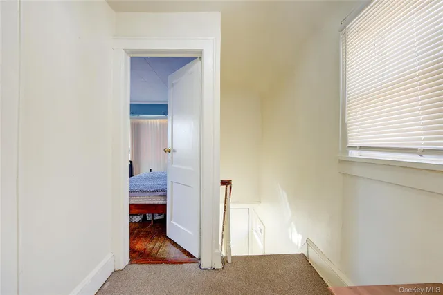 a view of a room that has a bed and a table in it