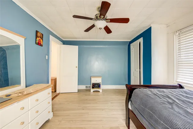 a bedroom with a bed and a ceiling fan