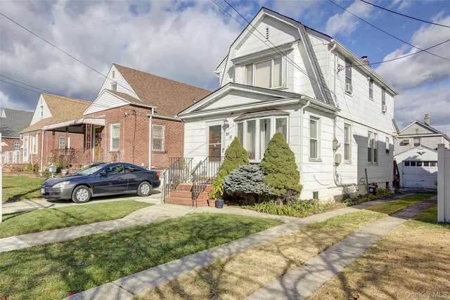 a car parked in front of a white house