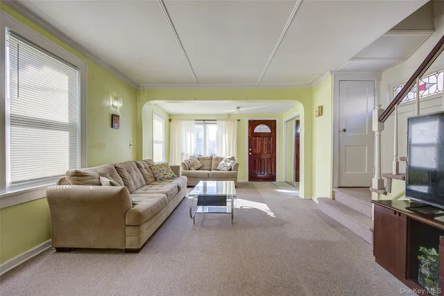 a living room with furniture a flat screen tv and a large window