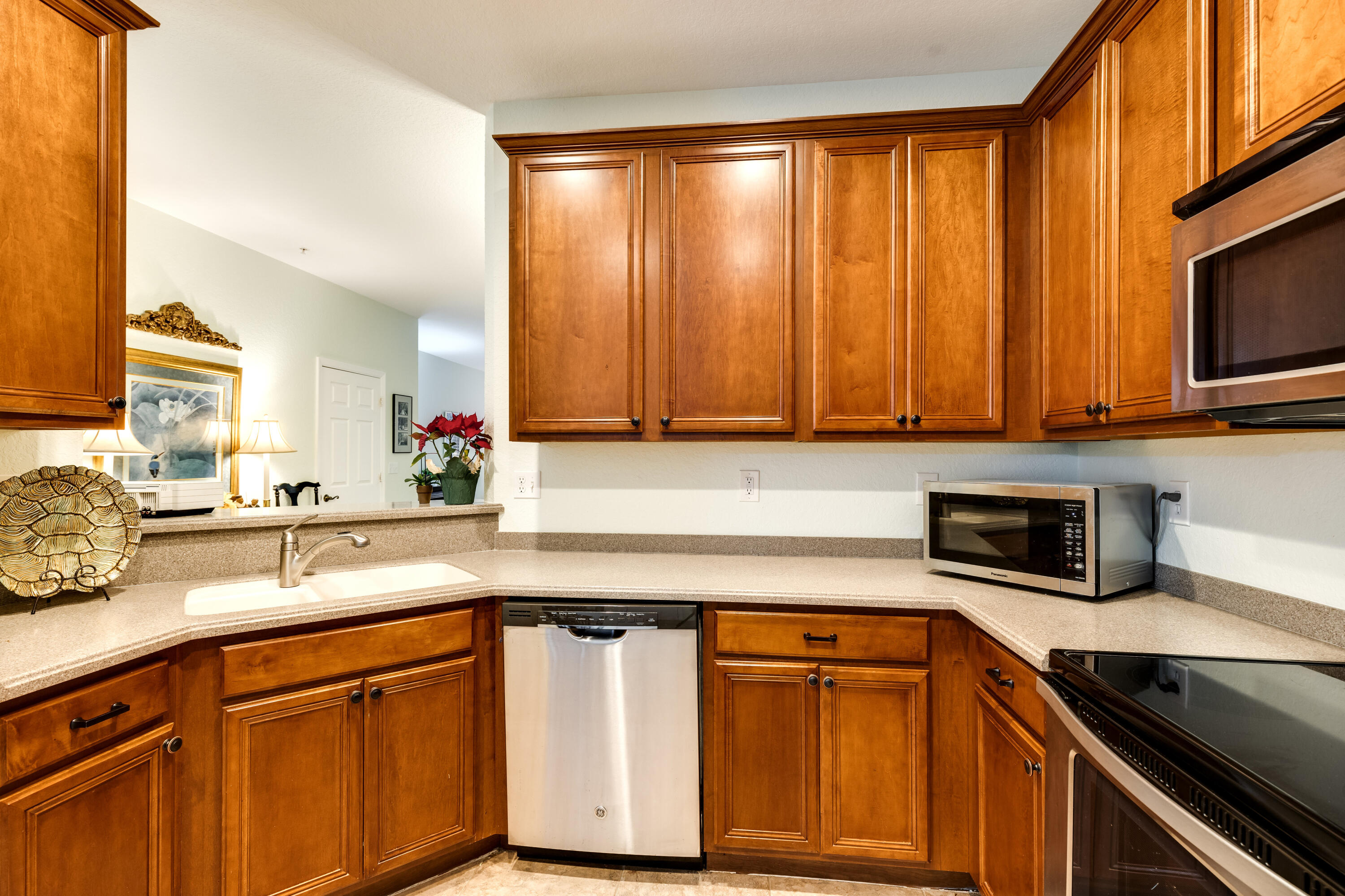 156 Village Boulevard, Unit E Tequesta, FL 33469 - Photo 12 of 36 a kitchen with stainless steel appliances granite countertop a sink a stove microwave and cabinets