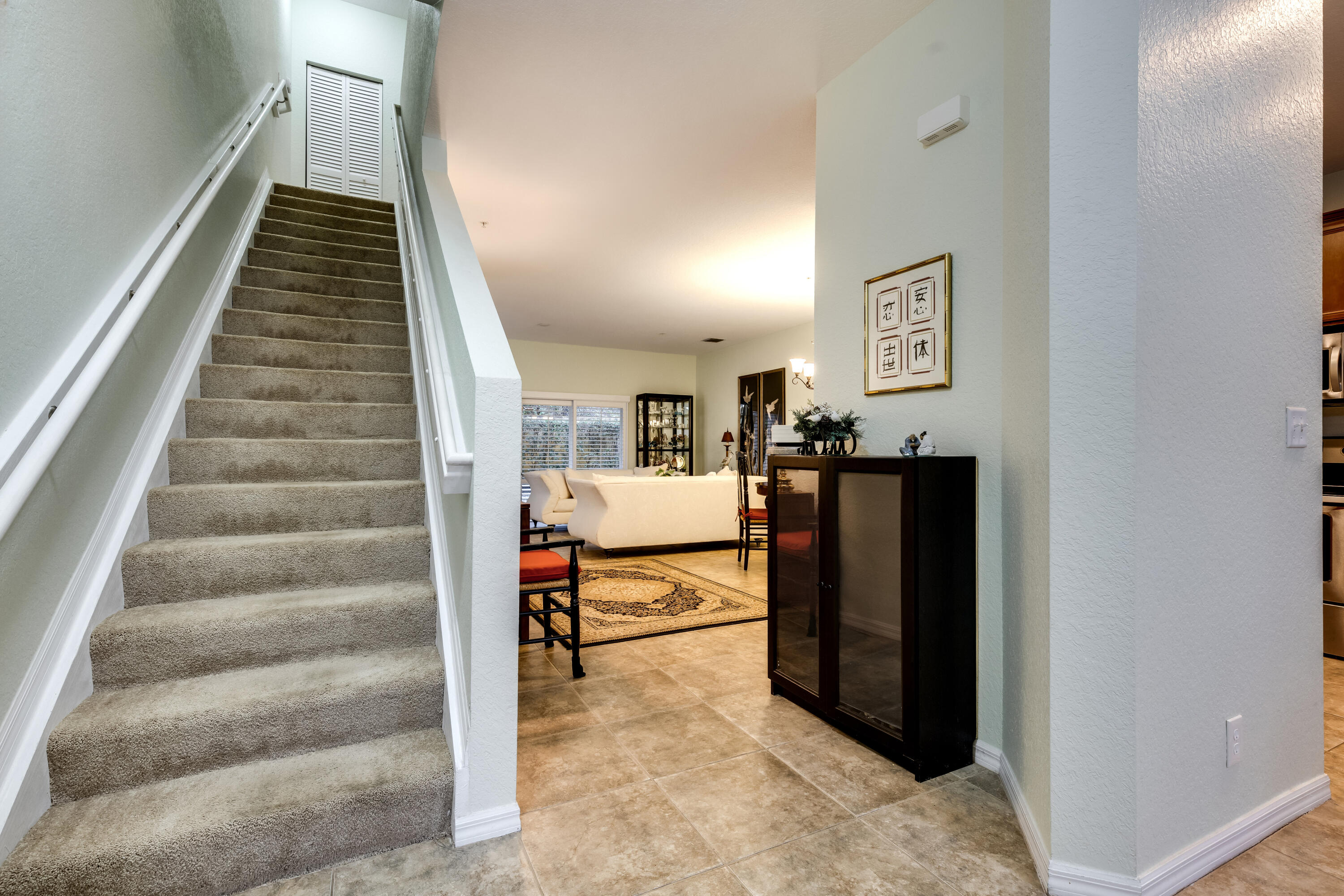 156 Village Boulevard, Unit E Tequesta, FL 33469 - Photo 16 of 36 a bedroom with stairs and furniture