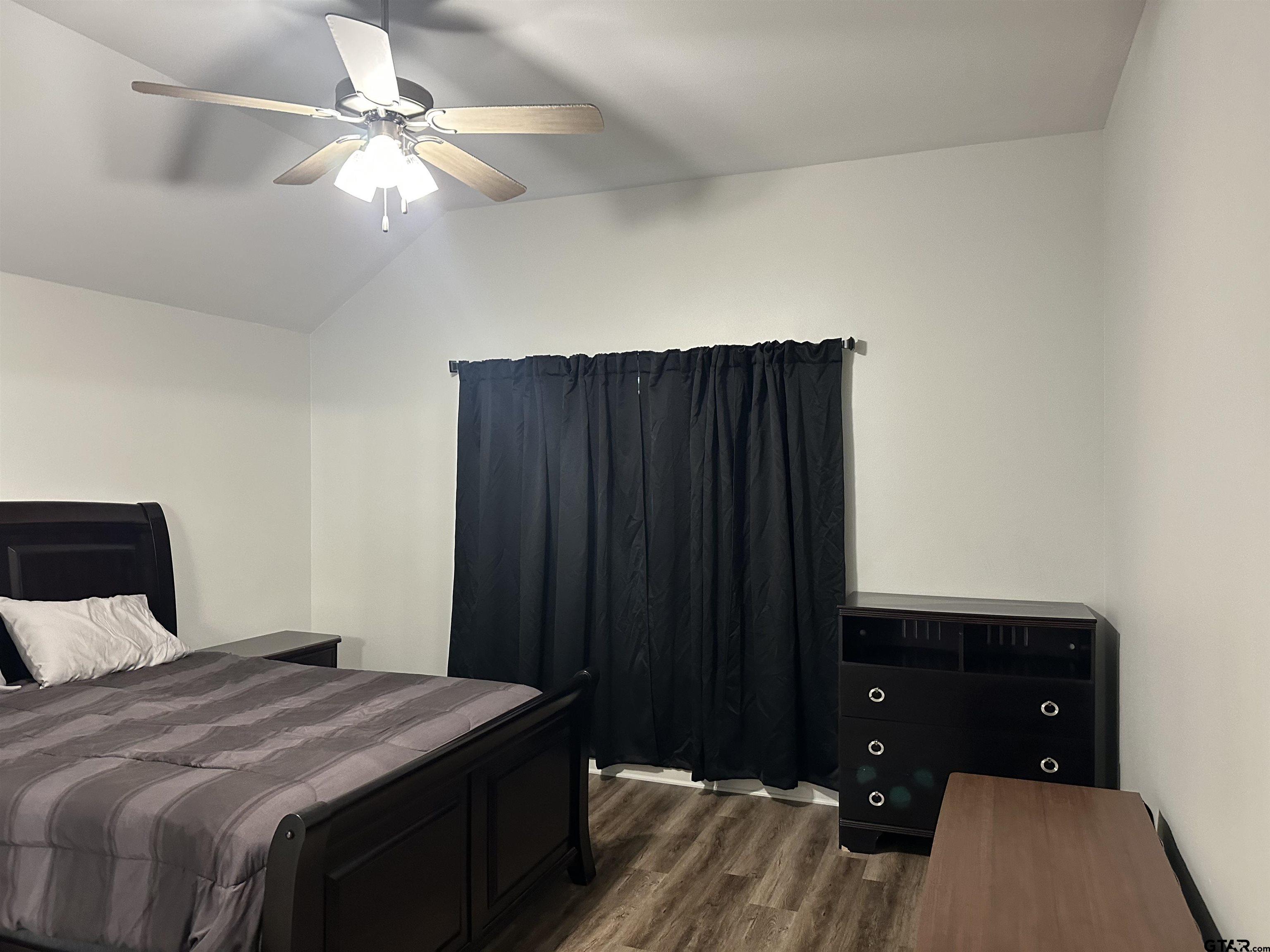 411 Deer Point Cove Chandler, TX 75758 - Photo 11 of 21 a bedroom with a bed and a chandelier
