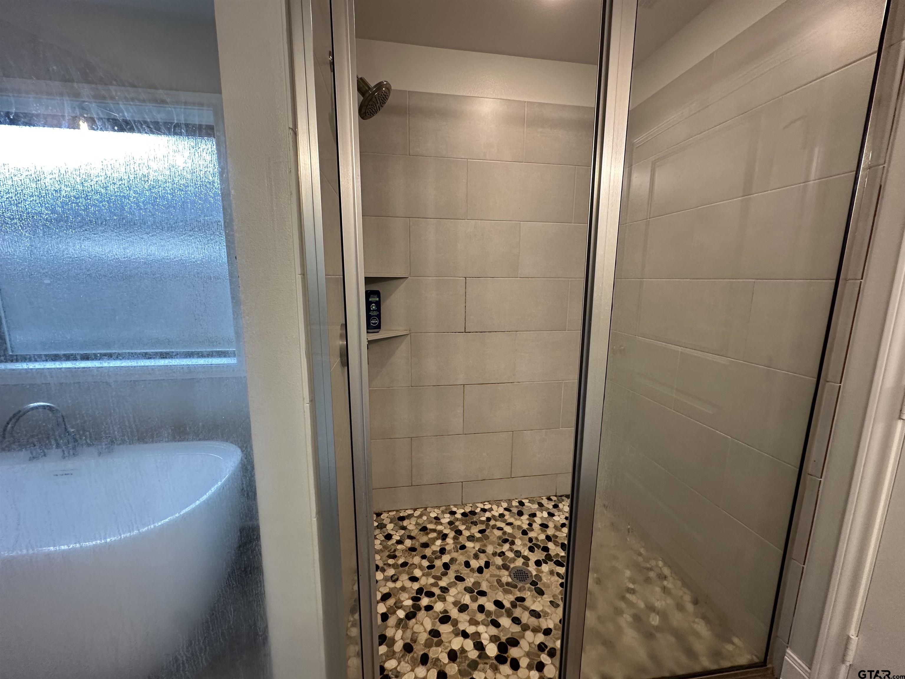 411 Deer Point Cove Chandler, TX 75758 - Photo 14 of 21 a bathroom with a bathtub and a shower