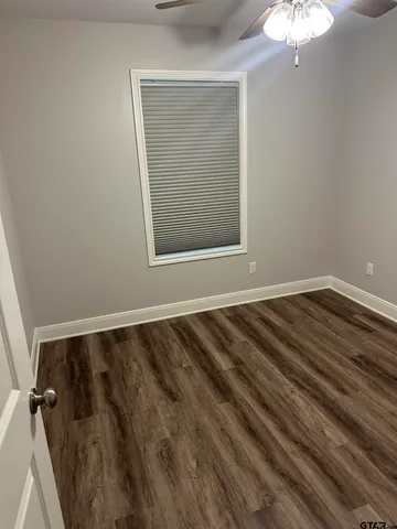 a view of a room with wooden floor and a window