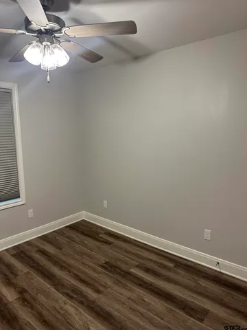 a view of a room with wooden floor and chandelier fan