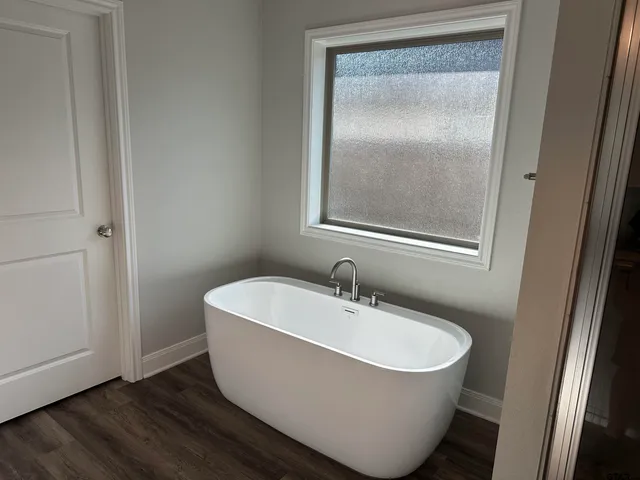 a white bath tub sitting next to a shower