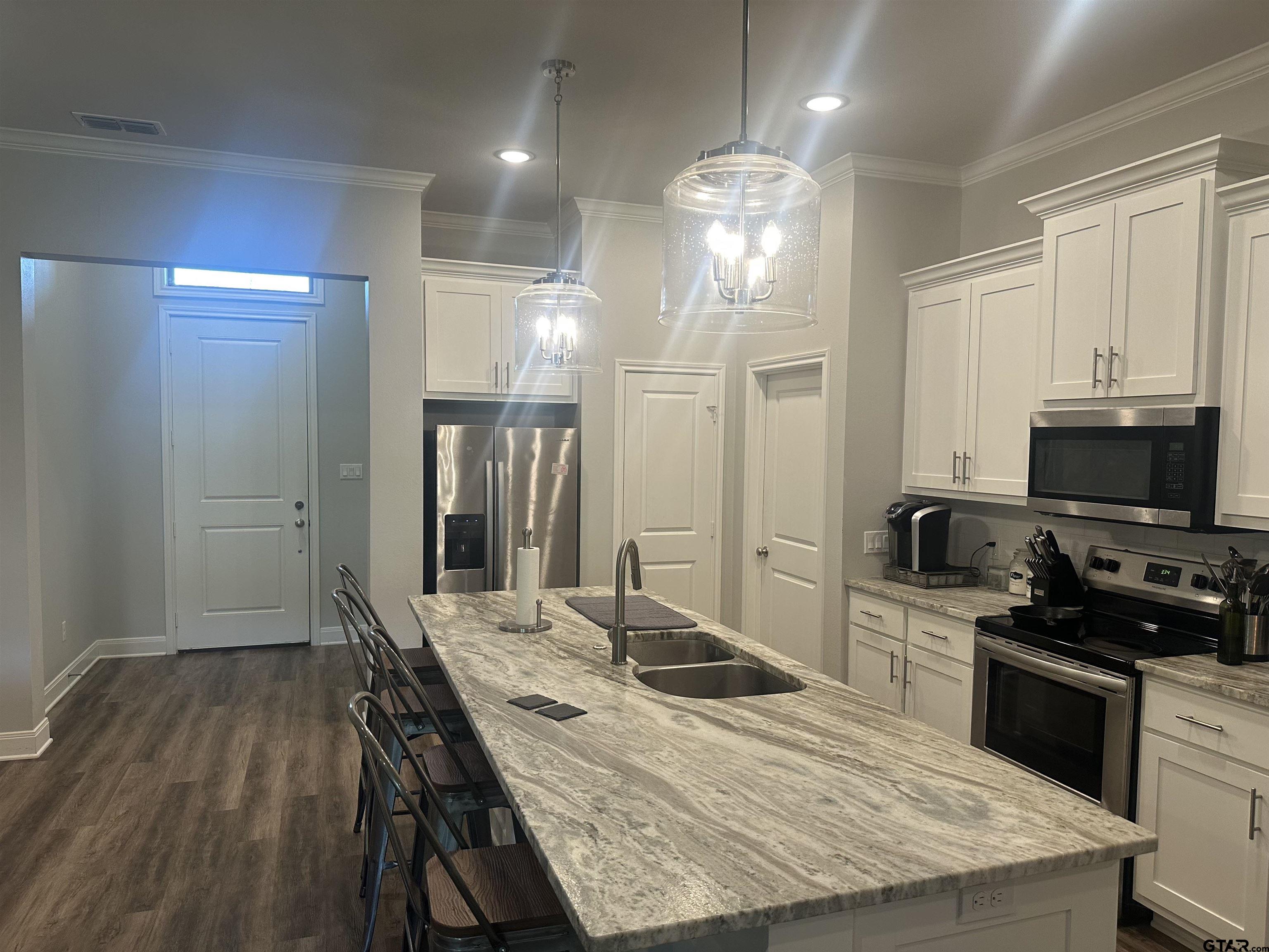 411 Deer Point Cove Chandler, TX 75758 - Photo 5 of 21 a kitchen with a table chairs refrigerator and microwave