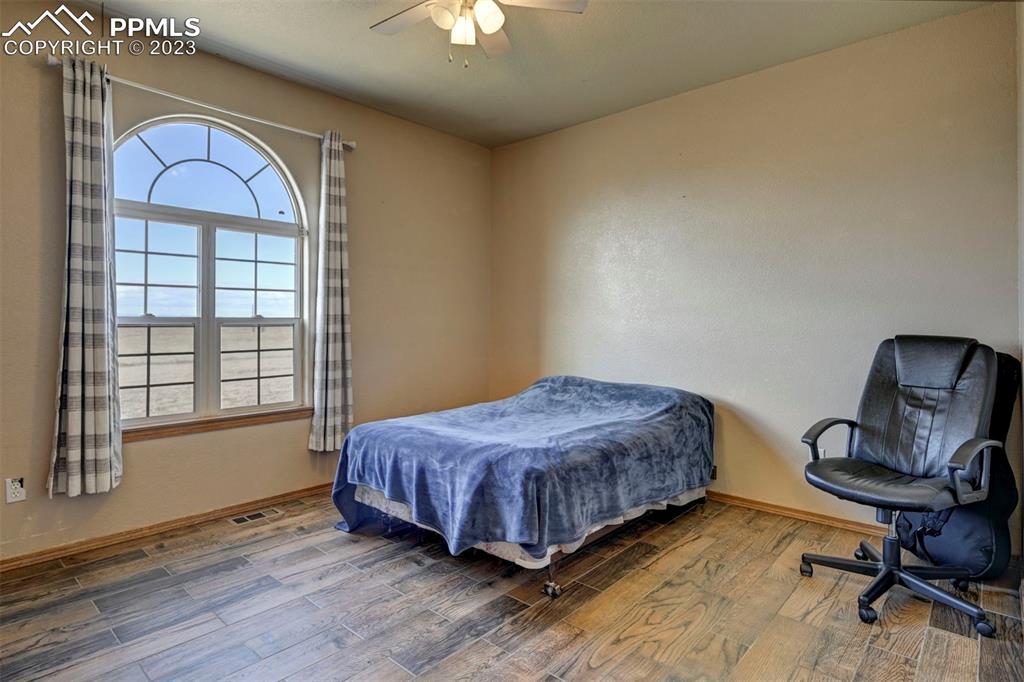 31790 Sanborn Road Yoder, CO 80864 - Photo 22 of 50 a bedroom with a bed window and chair