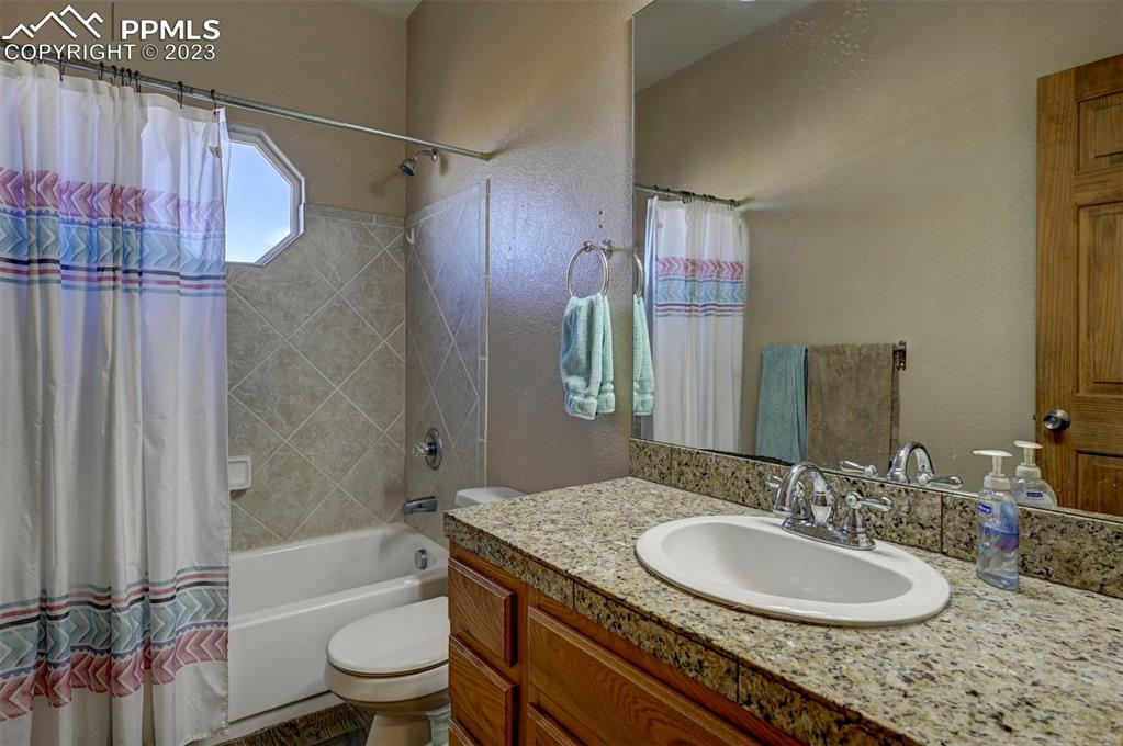 31790 Sanborn Road Yoder, CO 80864 - Photo 26 of 50 a bathroom with a granite countertop sink toilet and shower