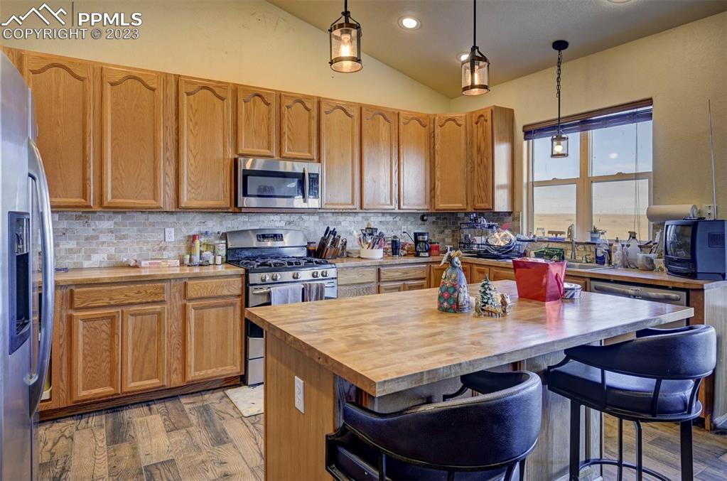 31790 Sanborn Road Yoder, CO 80864 - Photo 10 of 50 a kitchen with granite countertop a stove a sink dishwasher and cabinets with wooden floor