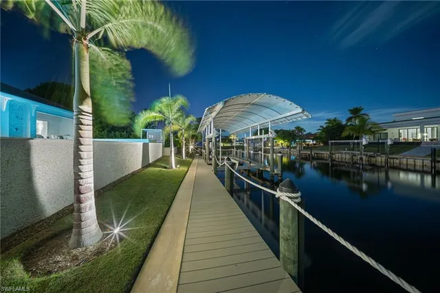 a large kitchen with kitchen island a stove a sink dishwasher and a dining table with wooden floor