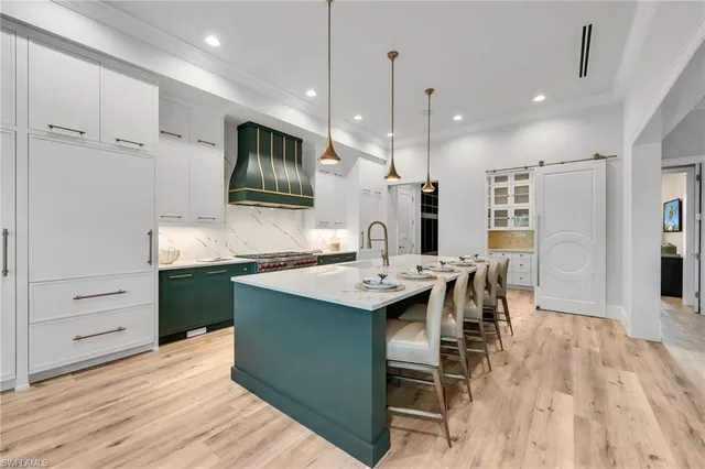 a kitchen with kitchen island a sink stove and wooden floor