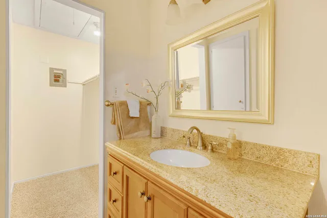a bathroom with a granite countertop sink and a mirror